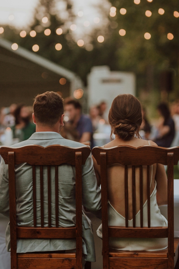 bride and groom sat down facing away from the camera 