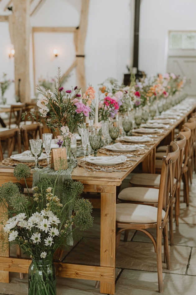 long table set up with flowers and other wedding décor