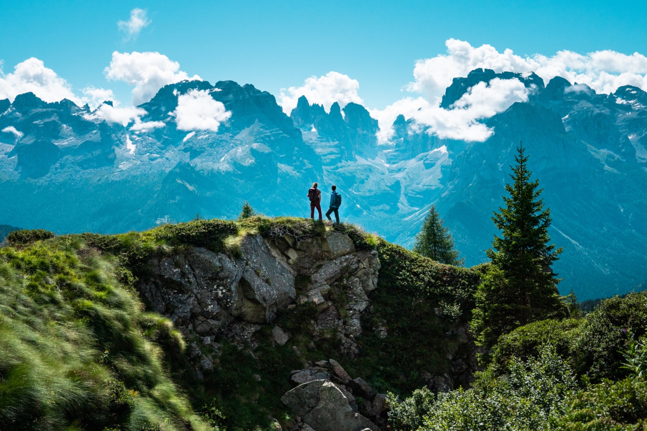 NOWtwo people stood on a mountain