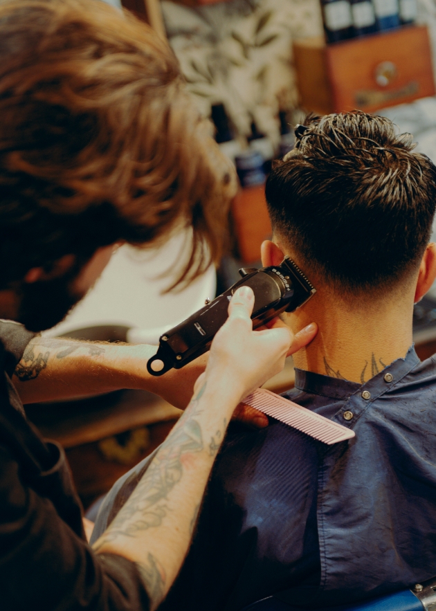man getting his hair cut by another man 