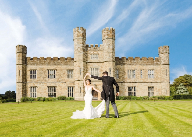 BRIDE AND GROOM DANCING IN FRONT OF CASTLE