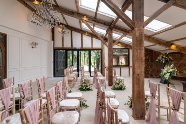 chairs set up on converted barn with pink details 