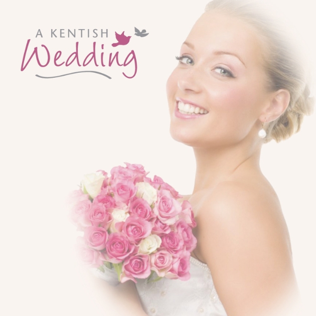 A bride smiling at the camera holding a bouquet of pink and white flowers