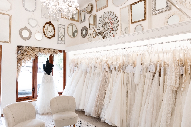 The interior of a bridal boutique with a rack of wedding dresses