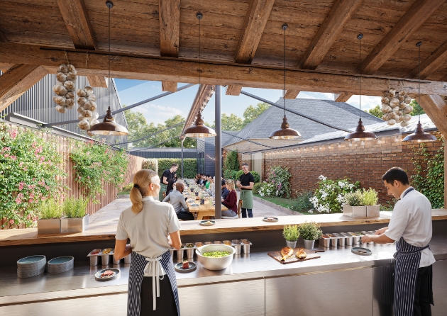 Two staff working behind a bar serving food with people seated chatting in the background