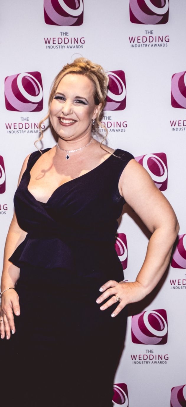 A woman in a black dress smiling at the camera