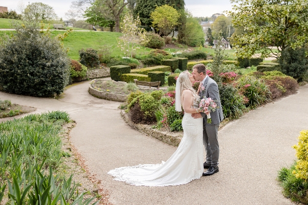 A bride and groom embracing in a garden