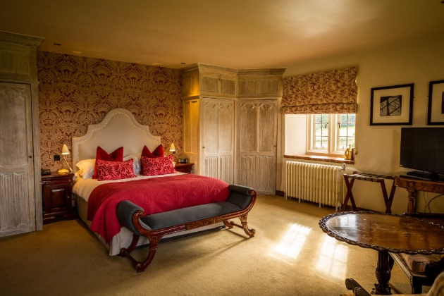 A neutral-decorated room with a red double bed