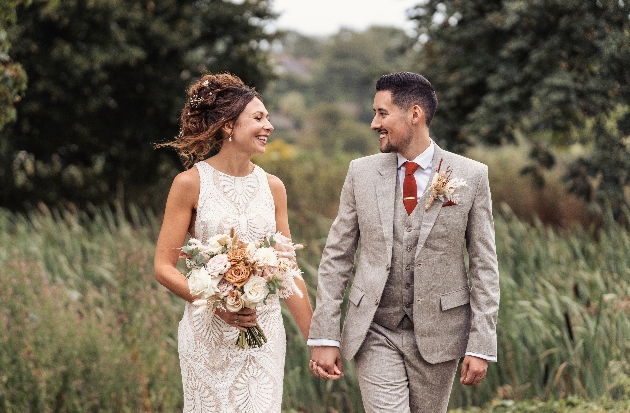A bride and groom walking hand in hand