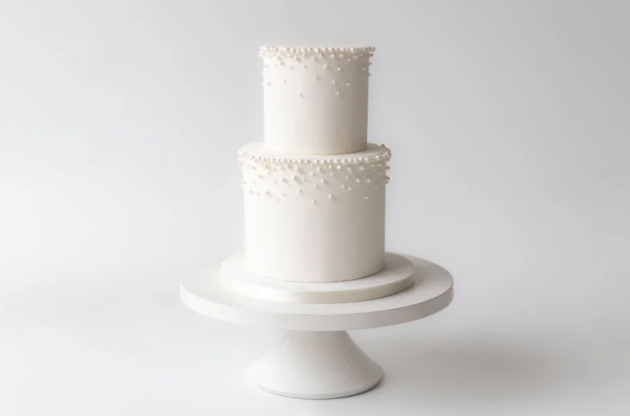 tiered elegant white iced cake with pearls