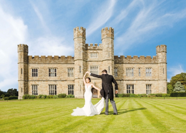 married couple dancing in front of the castle