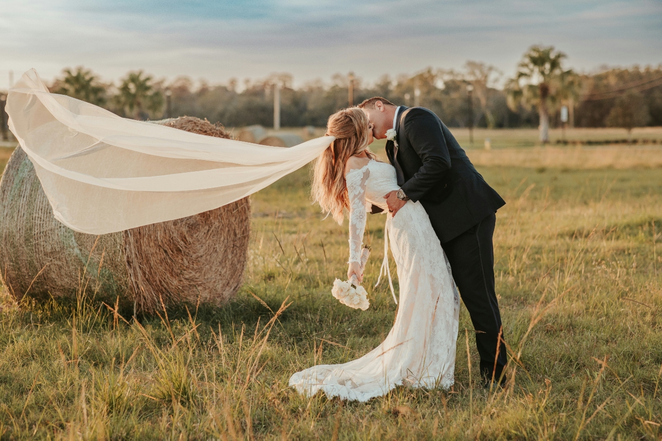 bride and groom outdoor in front of haybale